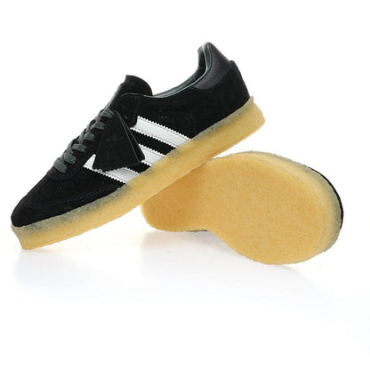 Black Adidas sneaker with white stripes on a white background