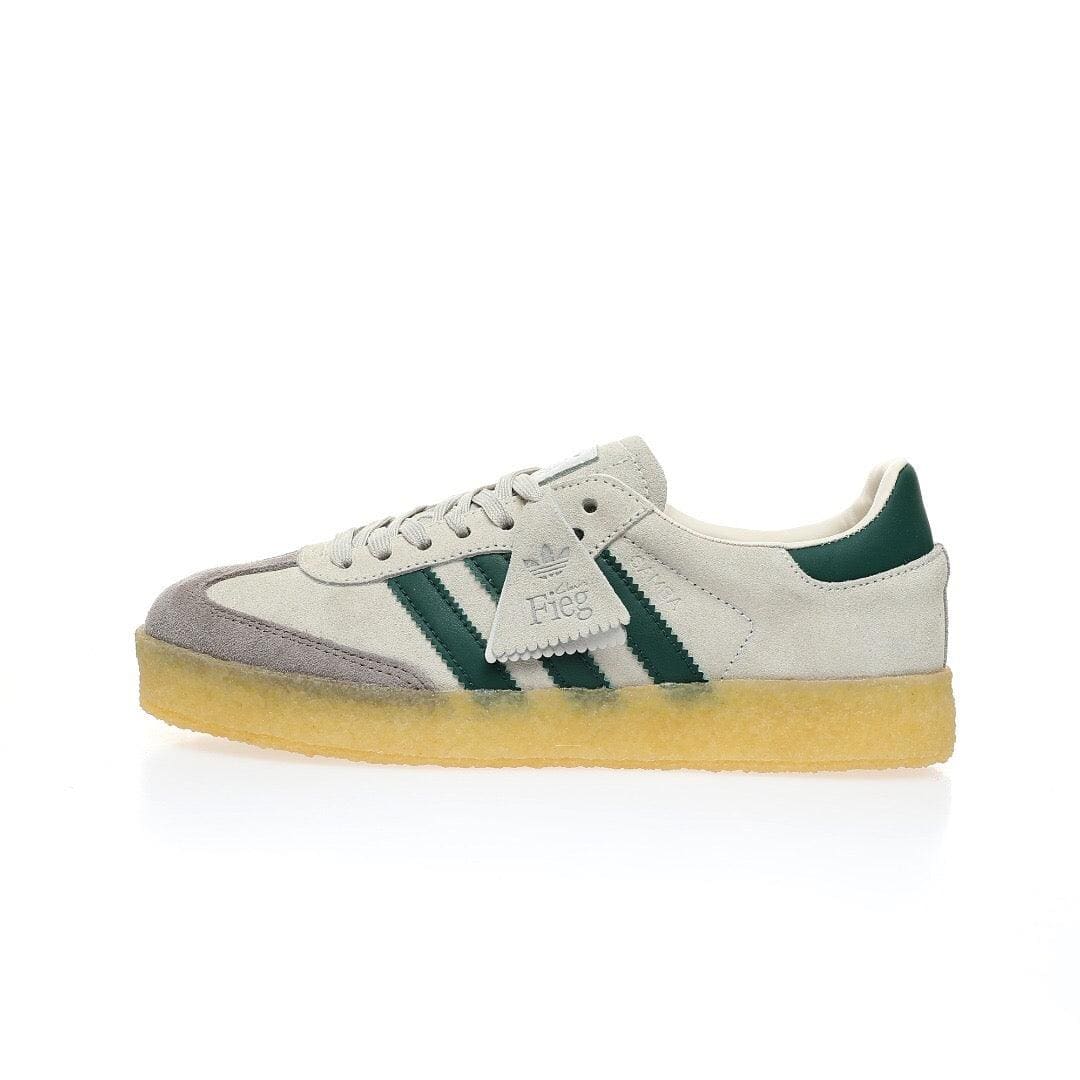 White Adidas sneaker with green accents on a white background