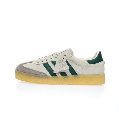 White Adidas sneaker with green accents on a white background