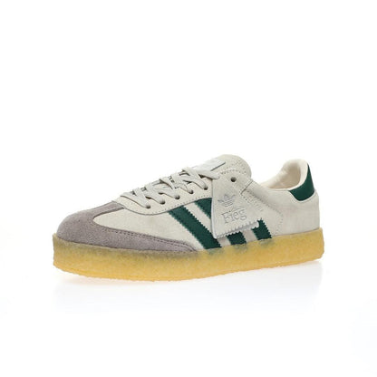 An Adidas Samba sneaker featuring a light beige suede and grey mesh upper, dark green three-stripes and heel tab, and a translucent yellow gum sole, shown against a plain white background.
