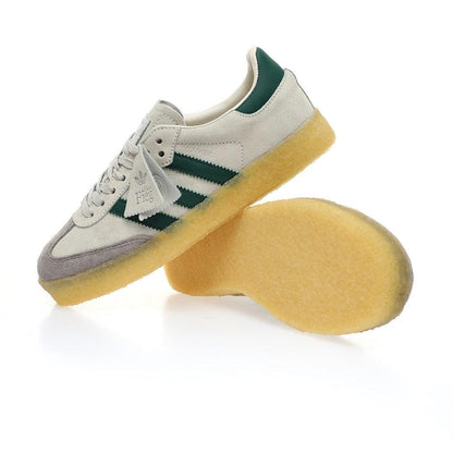 White sneakers with green stripes and yellow soles on a white background