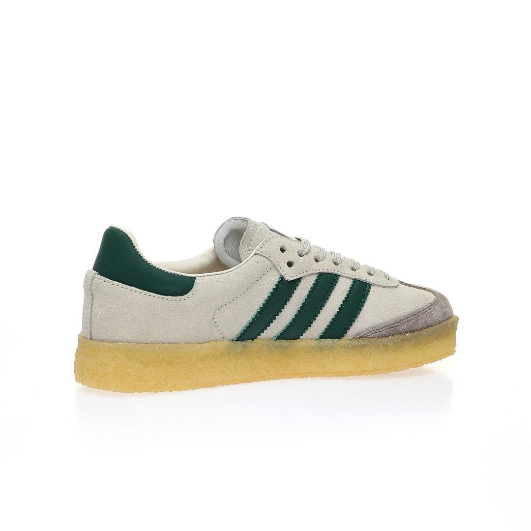 A classic Adidas Gazelle sneaker in off-white suede with dark green stripes and heel tab, featuring a gum sole, shown from a side profile on a white background.