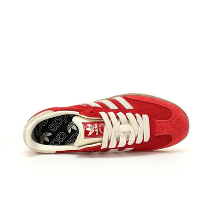 A red Adidas Yeezy Boost 380 sneaker shown from a side profile view against a plain white background. The shoe features a red suede upper, white leather stripes, white laces, and a black patterned insole with the Adidas trefoil logo.