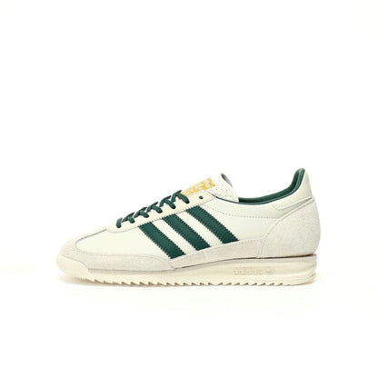 A single Adidas Samba sneaker in off-white suede and leather with dark green stripes, laces, and collar, featuring a gold tongue label, shown in profile against a white background.
