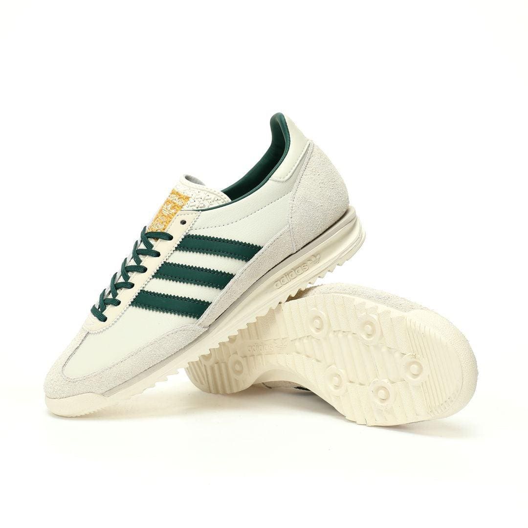White sneakers with green stripes on a white background