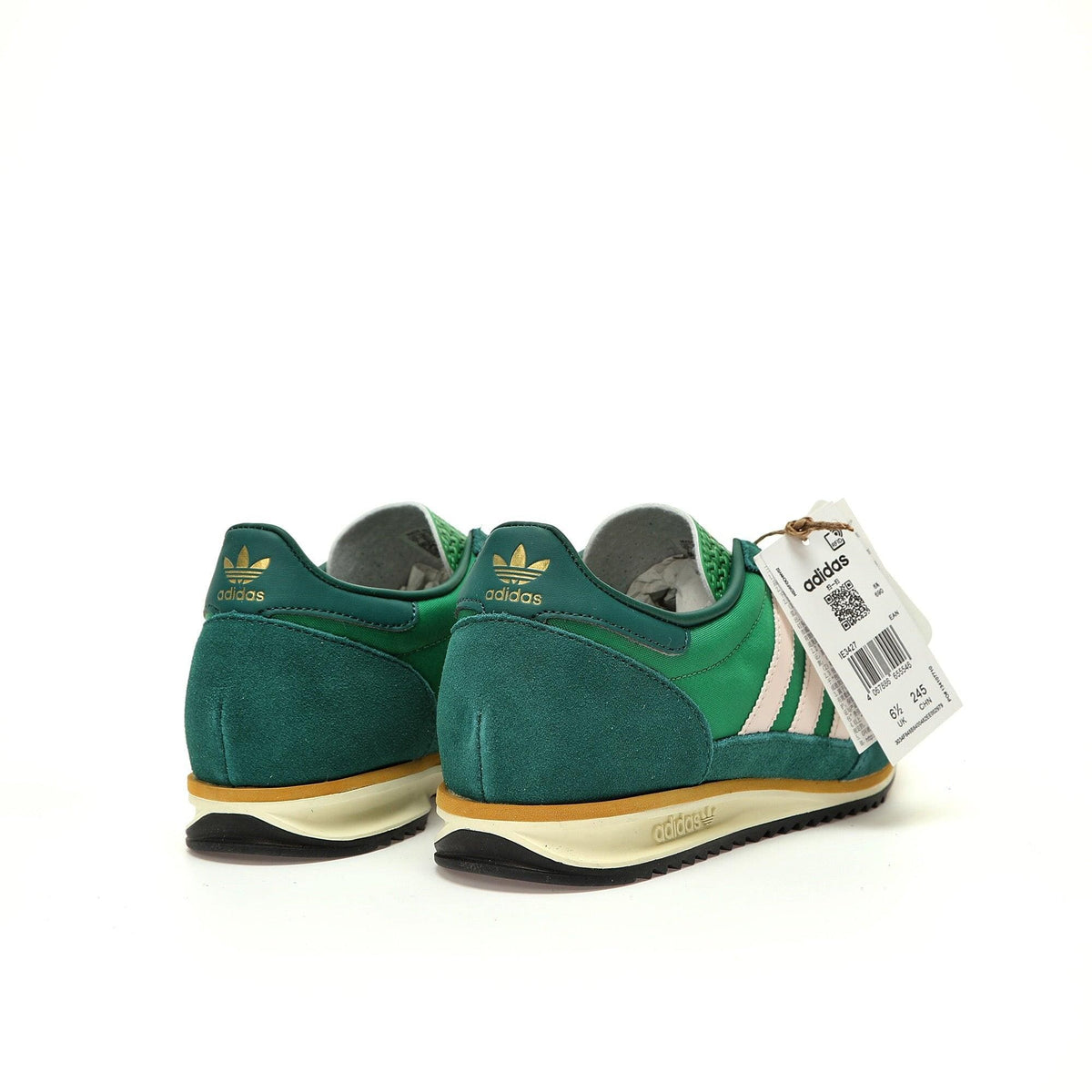 Green Adidas sneakers with a visible tag on a white background