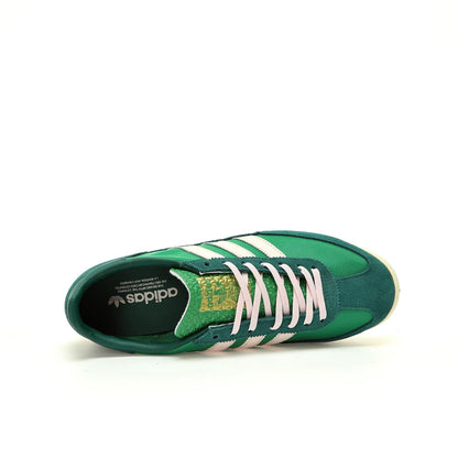 Green Adidas sneaker with white stripes on a white background