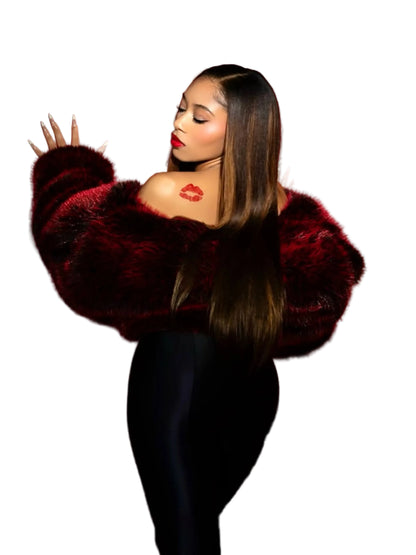 Woman wearing a fur coat against a pink background