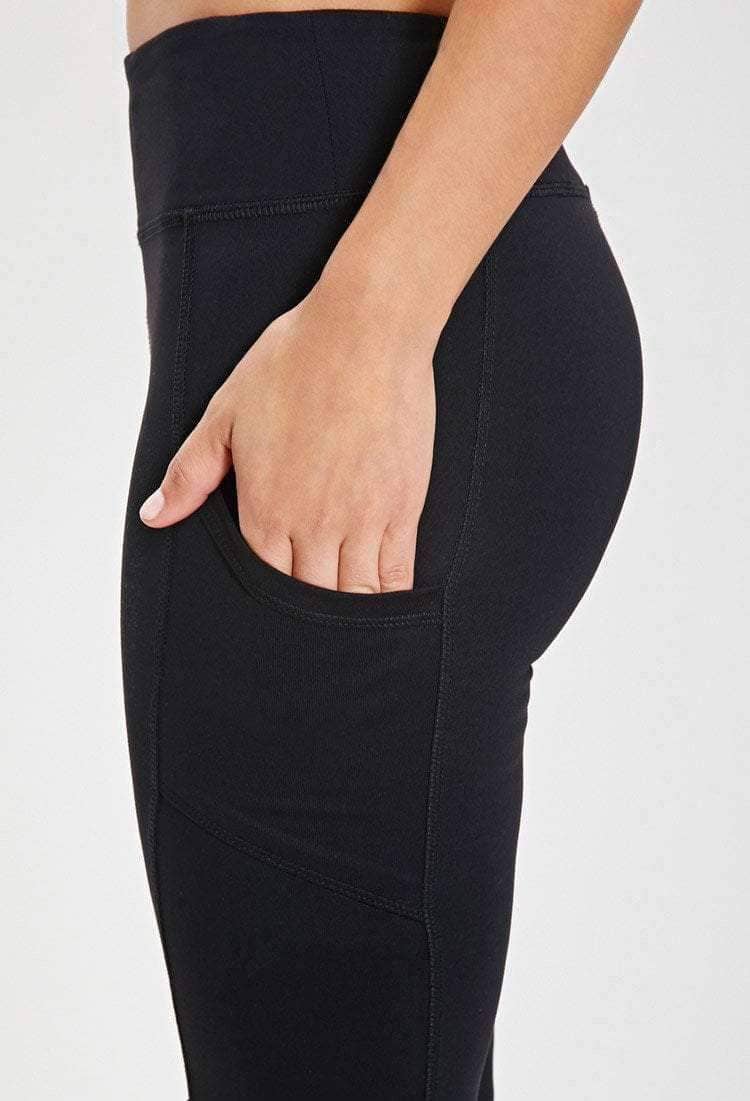 Person wearing black leggings with a plain background