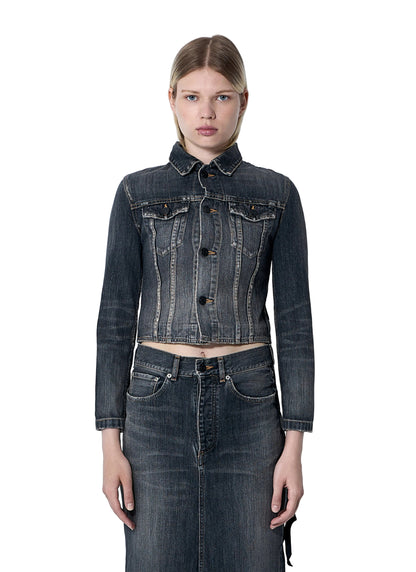 Woman wearing a dark denim jacket and skirt against a light gray background