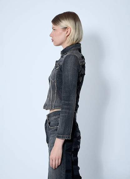 Person wearing a dark denim jacket and pants on a white background