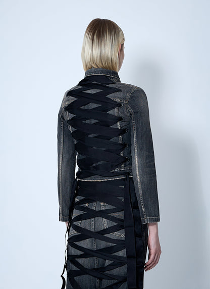 Person wearing a black denim jacket with geometric cut-out design on a white background
