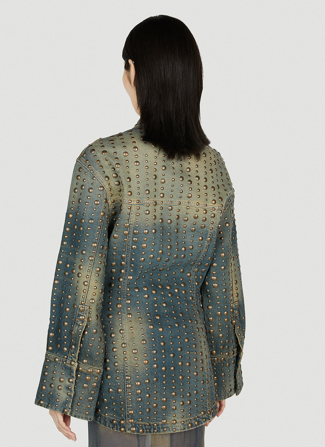 Woman wearing a patterned jacket on a plain background