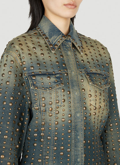 Denim jacket with gold studs worn by a person on a light gray background