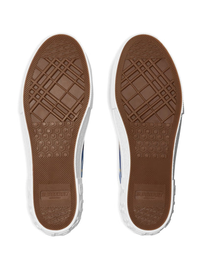 Brown sole of a shoe with a visible brand logo on a white background