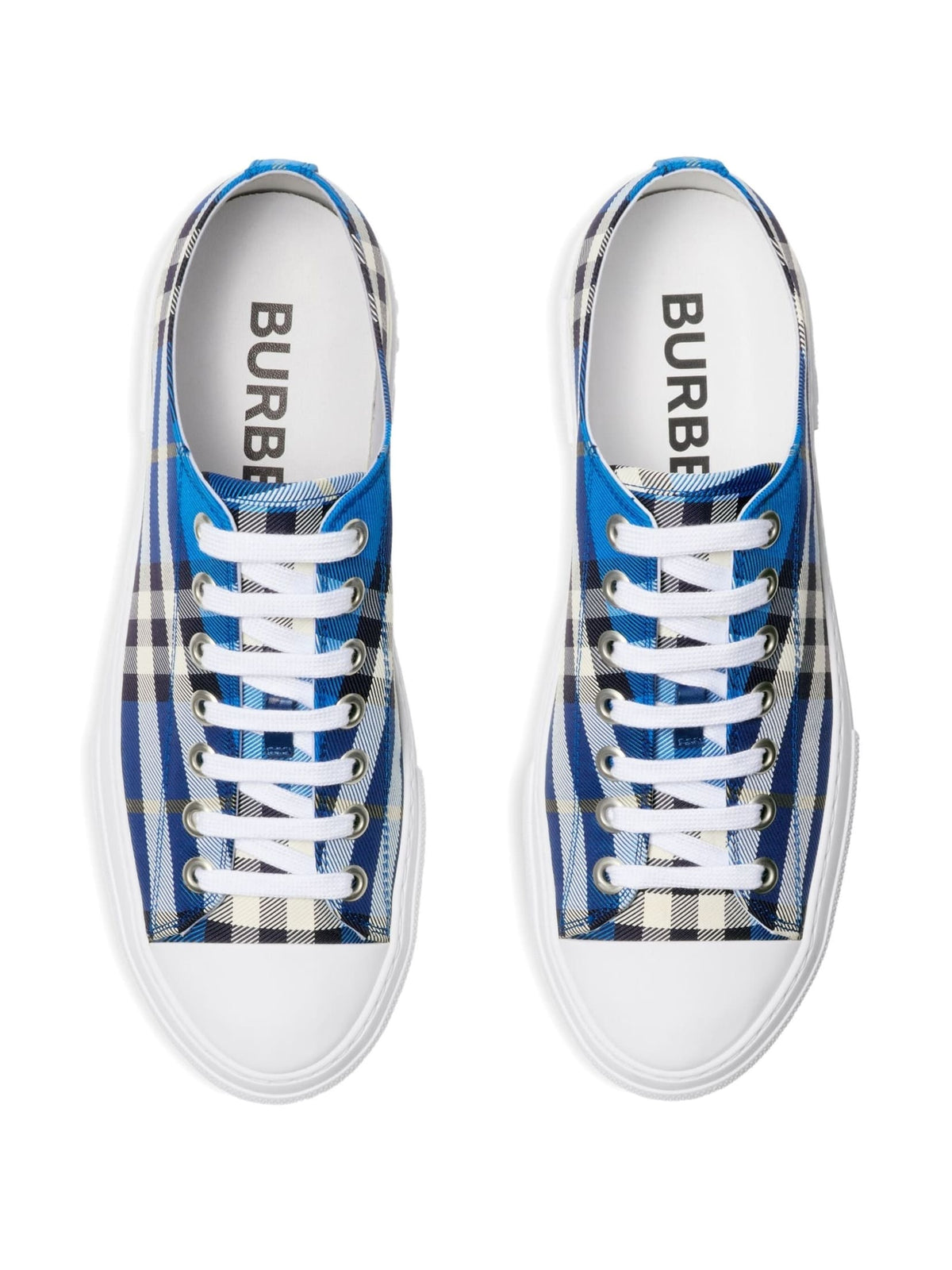 A pair of Burberry low-top sneakers shown from a top-down view. The shoes feature a blue, white, and black plaid pattern on the canvas uppers, white laces, and white rubber soles.