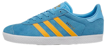 A light blue suede Gazelle sneaker with three yellow stripes, a light blue collar, and a white textured sole.