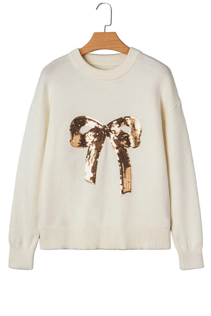 White sweater with a gold sequin bow on a gray background