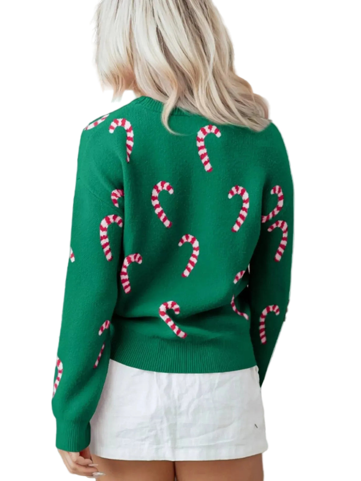 Person wearing a green sweater with candy cane patterns in a festive setting.