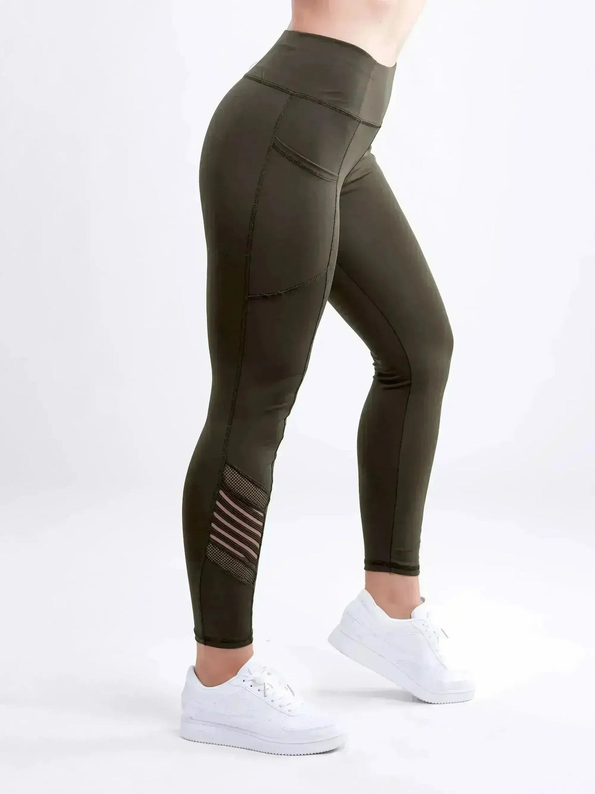 Olive green leggings with white sneakers on a white background