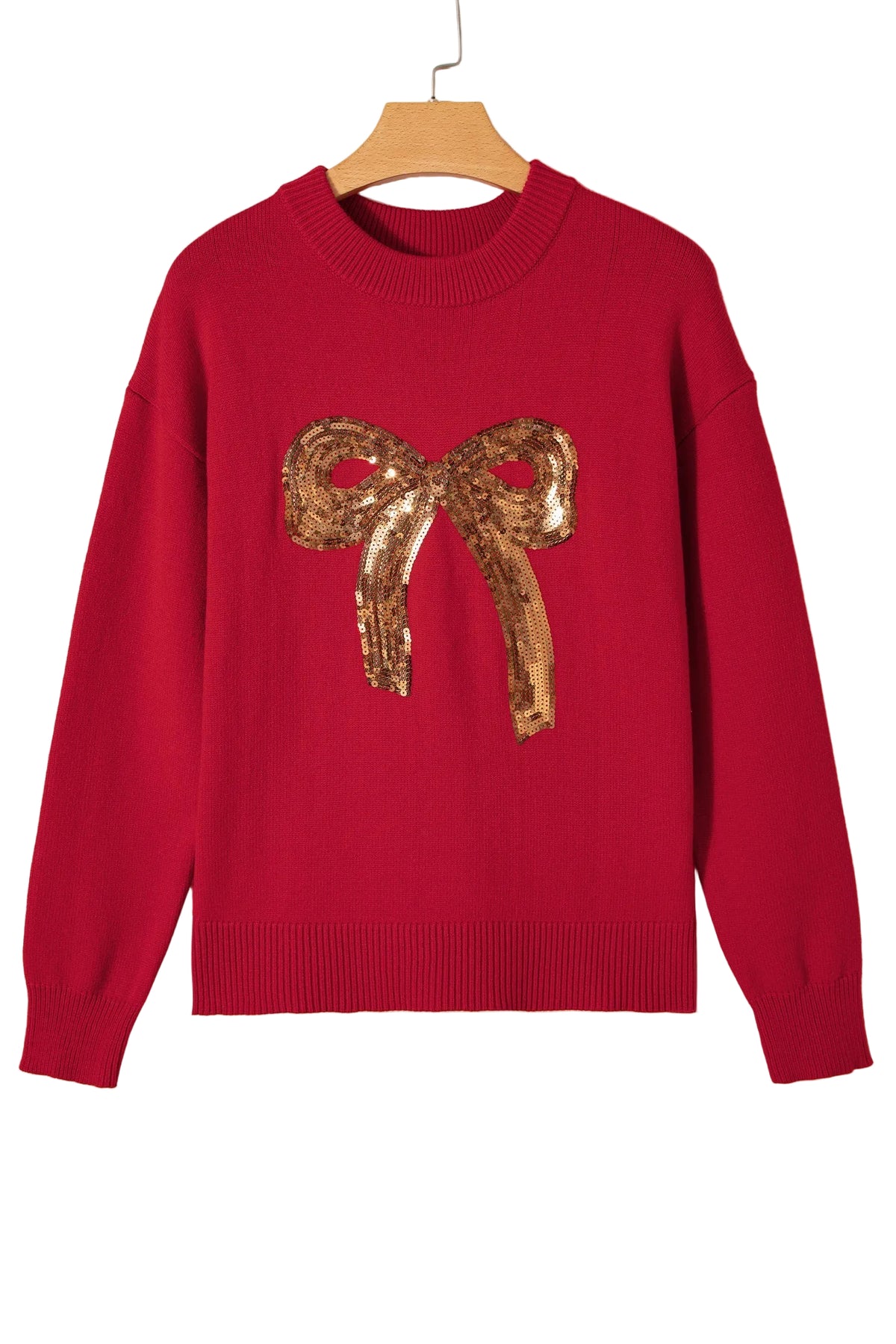 Red sweater with a gold sequin bow on a beige background