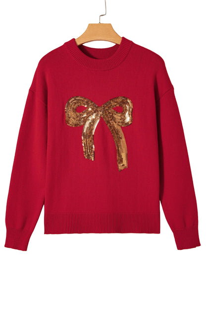 Red sweater with a gold sequin bow on a beige background