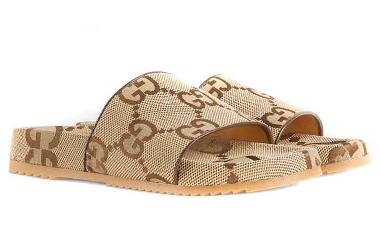 Beige slide sandals with a patterned strap on a white background