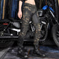 Person wearing camouflage pants and black boots standing in front of a motorcycle.