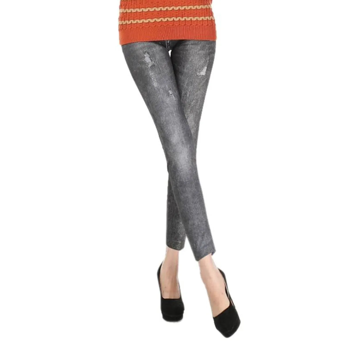 Person wearing gray distressed jeans and an orange sweater on a white background