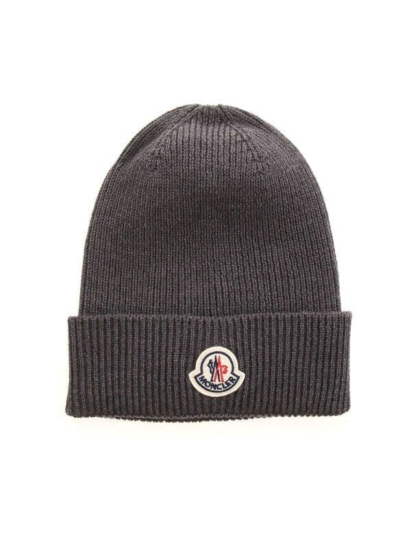 A dark gray ribbed knit beanie hat featuring a folded cuff with a circular embroidered Moncler logo patch.