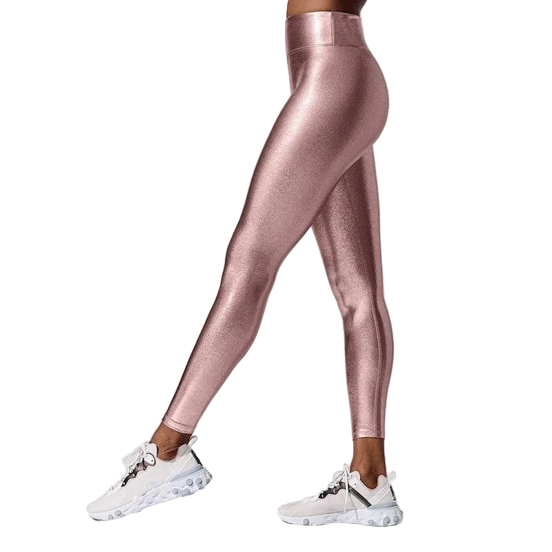 Rose gold leggings worn by a person on a light gray background