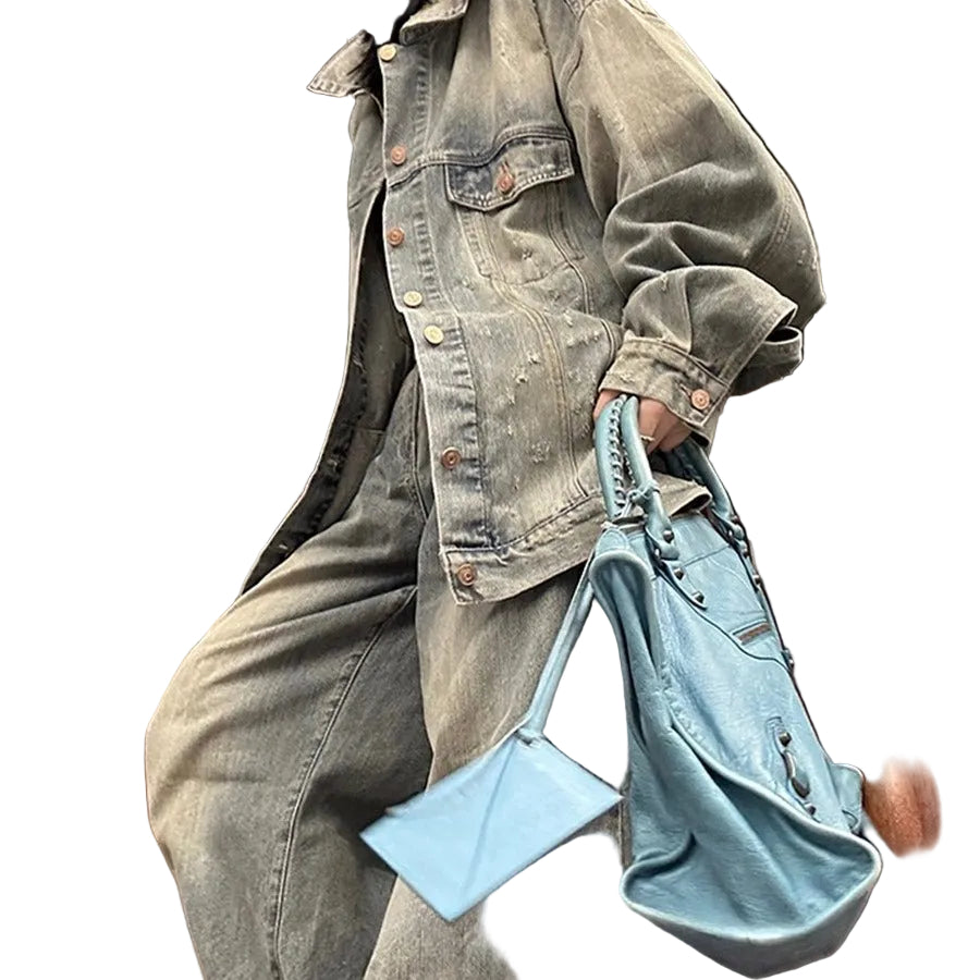 Person wearing a denim jacket and holding a blue handbag on a staircase.